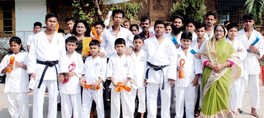 Sports organiser Abdus Kuddus posed for photograp with the Karate belt achievers from Satokan Karate School, Boddarhat Branch recently.