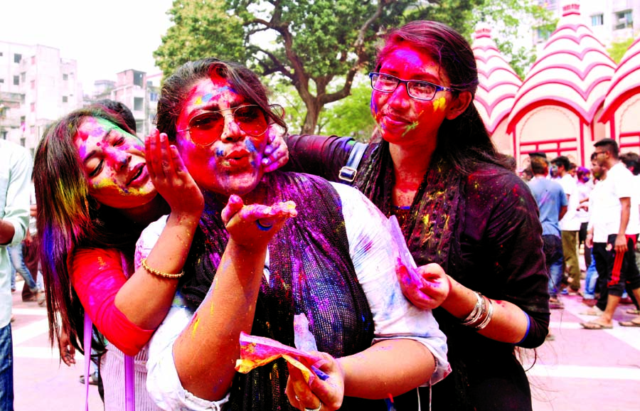 Some girls of the Hindu community anoint colour powder with one another at a Holi festival of the community marking Dol Purnima. The snap was taken from the city's Dhakeshwari National Temple on Sunday.