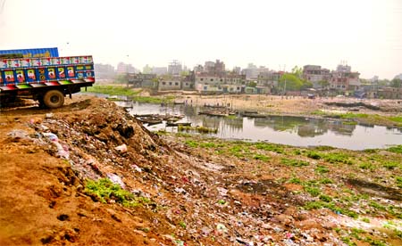 Encroachers again occupying the lands of Buriganga tributaries despite court order. This photo was taken from city's Mohammadpur Beribanh area on Sunday.