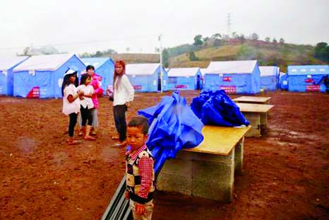 Refugees who fled fighting in neighbouring Myanmar stand in a Chinese disaster relief tent camp in the town of Nansan, Yunnan province, China on Sunday.