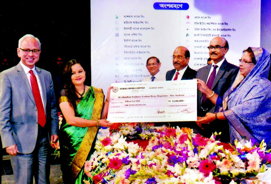 State Minister for Women and Children Affairs Meher Afroz Chumki, handing over an SME loan cheque to a Woman Entrepreneur on behalf of Pubali Bank Ltd at `Banker Nari Uddokta Somabesh and Ponno Prodorshony Mela 2017' at a city auditorium recently. BB Gov