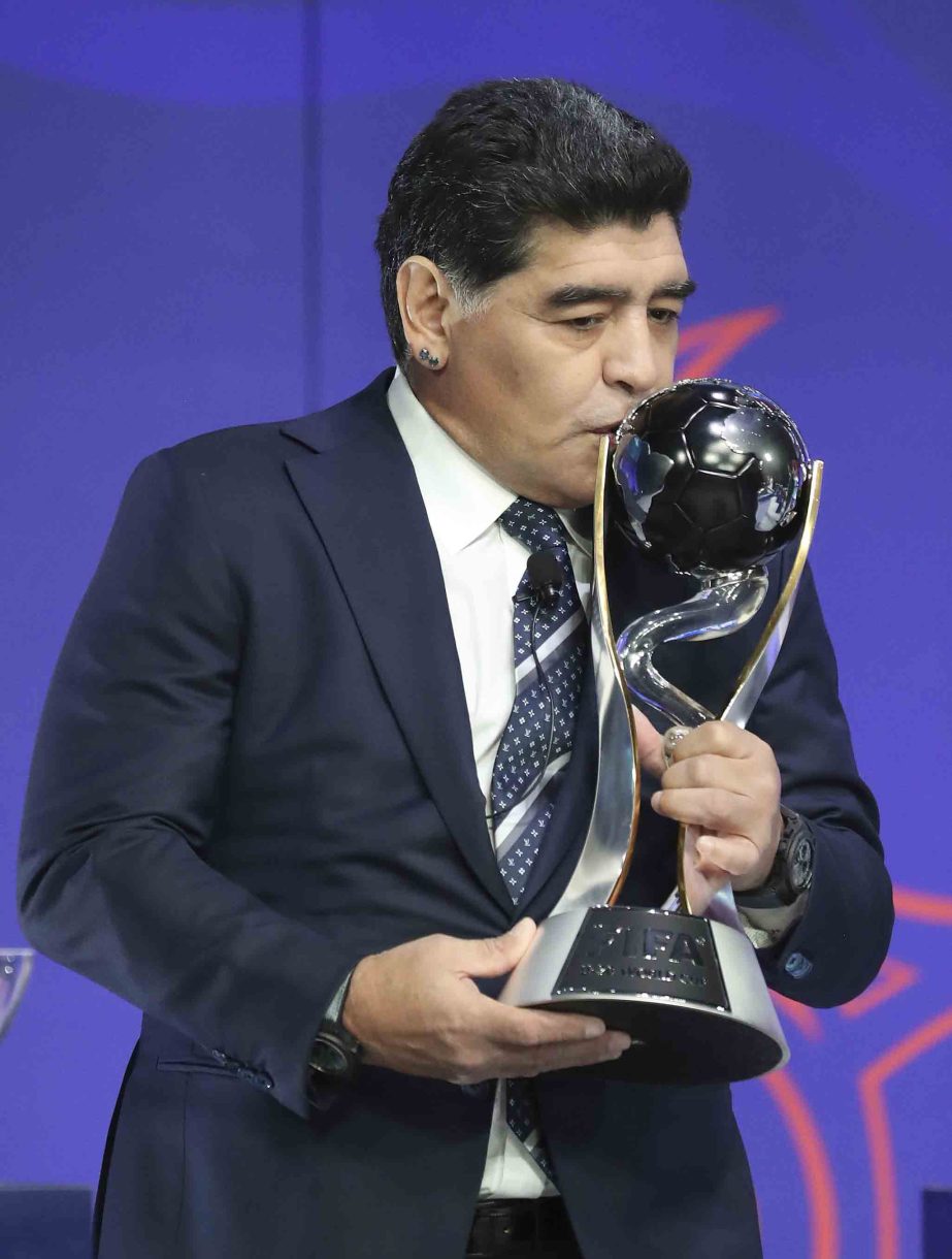 Argentina's former soccer player Diego Maradona kisses the FIFA U-20 World Cup trophy upon his arrival for the official draw for the FIFA U-20 World Cup Korea 2017 in Suwon, South Korea, Wednesday. The FIFA U-20 World Cup Korea 2017 matches will be held