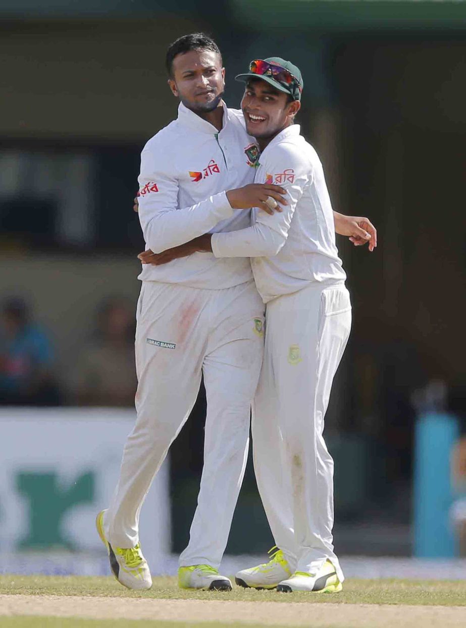 Bangladeshi bowler Shakib Al Hasan , left, celebrates the wicket of Sri Lanka's Niroshan Dickwella with teammate Mehedi Hasan Miraz on day one of their second Test cricket match in Colombo, Sri Lanka on Wednesday.