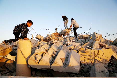 Israeli Arab boys stand on the rubble of houses demolished by Israeli bulldozers in the northern Israeli city of Qalansuwa