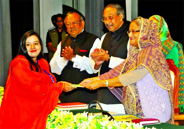 Prime Minister Sheikh Hasina handing over Bangabandhu Fellowship and NST Fellowship among the scientists and researchers of different universities and research institutions at Osmani Memorial Auditorium in the city on Thursday. BSS photo