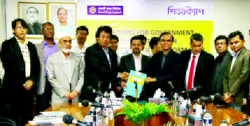 Sarder Nurul Amin, Deputy Managing Director of Sonali Bank and Dr. Shahadat Ullah Khan, CEO of SureCash exchanging documents after signed an agreement in the city on Monday. Under the deal, Sonali Bank has received permission from Bangladesh Bank to start