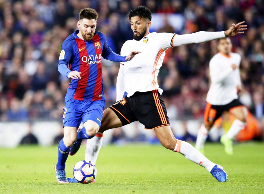 FC Barcelona's Lionel Messi (left) duels for the ball with Valencia's Ezequiel Garay during the Spanish La Liga soccer match between FC Barcelona and Valencia at the Camp Nou stadium in Barcelona, Spain, Sunday.