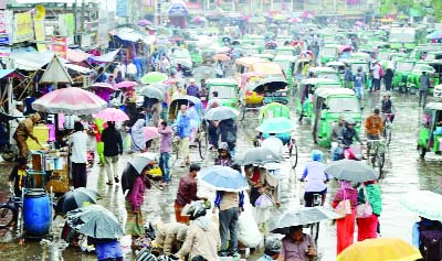 SYLHET: Working people in Sylhet in trouble due to sudden rainfall. This picture was taken from Court Point on Monday.