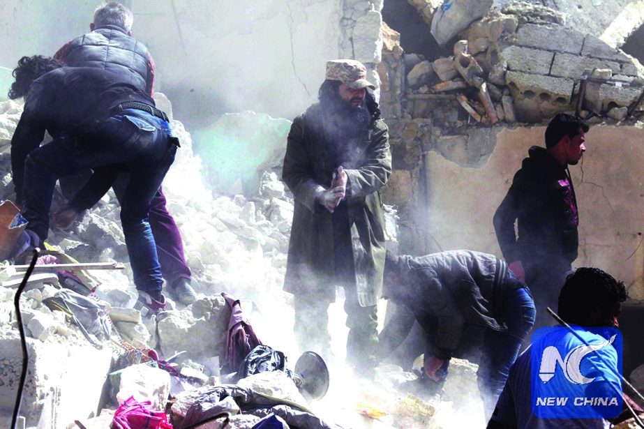 People remove rubble while looking for survivors at a damaged site after an airstrike on rebel-held Idlib city in Syria.