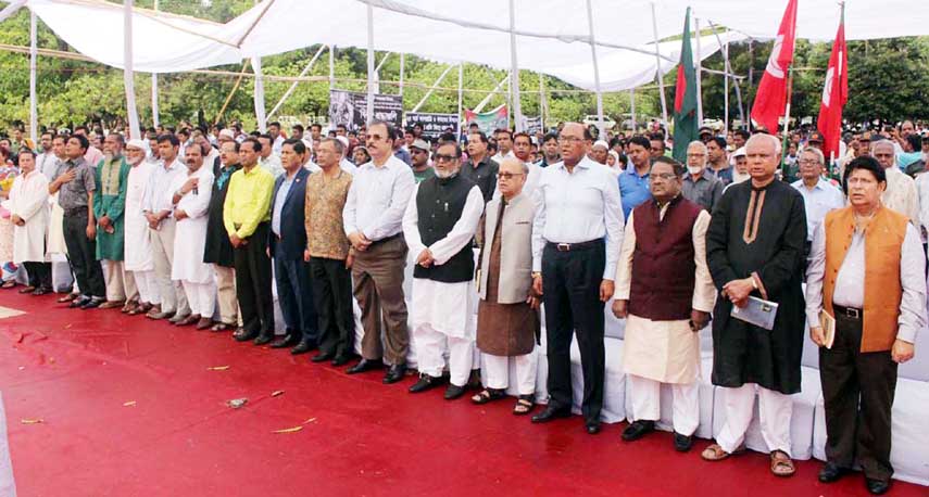 Liberation War Affairs Minister AKM Mozammel Haque, among others, stands in a solemn silence marking the Genocide Day at Shikha Chirantan (Eternal Flame) in the city's Suhrawardy Udyan on Saturday.