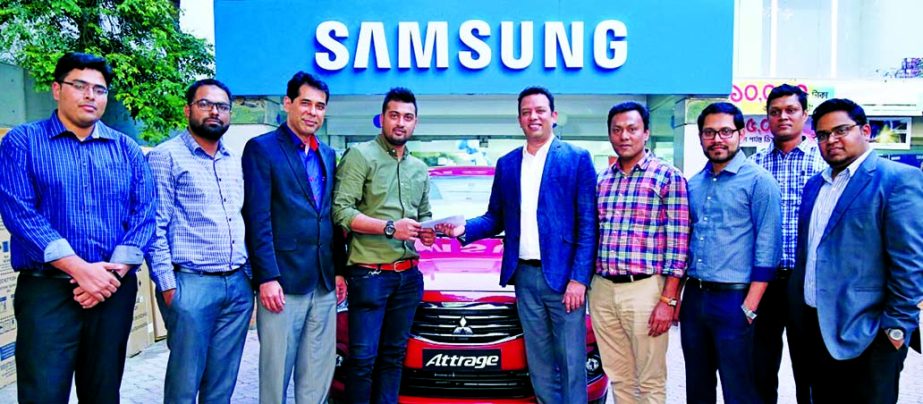 Firoze Mohammad, Head of Business of Samsung Electronics Bangladesh, handing over a car to SMA Mafi Shubho, winner of the 'Wedding Campaign' program at a city hotel recently. High officials from Transcom Digital, Rangs, Electra International and Fair El
