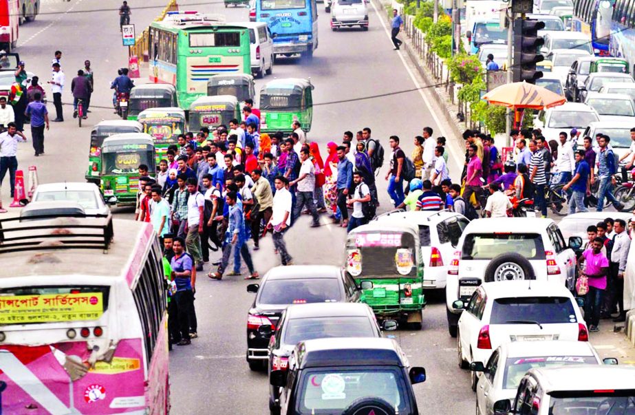 Careless to self-security and foot over bridge nearby they pass through busy road despite warning of fines, and jail term by mobile courts at different city points. Photo shows about hundred of men, women, and children crossing road at Kakoli risking thei