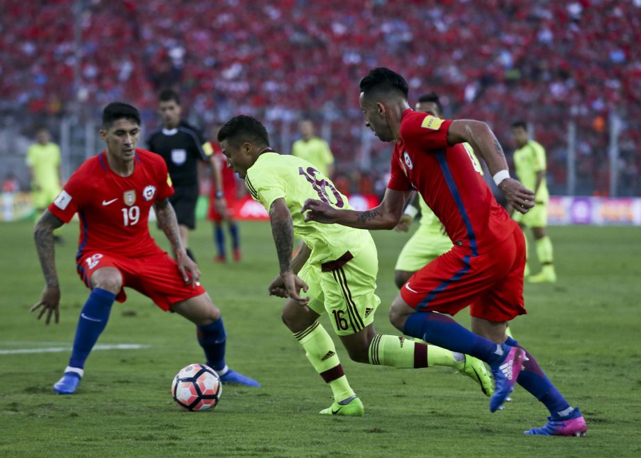 Venezuela's Darwin Machis (center) fights for the ball with Chile's Pedro Hernandez (left) and Mauricio Isla (right) during a 2018 World Cup qualifying soccer match in Santiago, Chile on Tuesday.