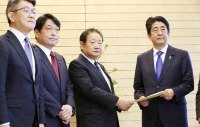 Hiroshi Imazu, second right, Chairman of Research Commission on Security of Japan's ruling Liberal Democratic Party (LDP) submits a proposal on missile defense to Japanese Prime Minister Shinzo Abe, right, flanked by former Defense Minister Itsunori Onod