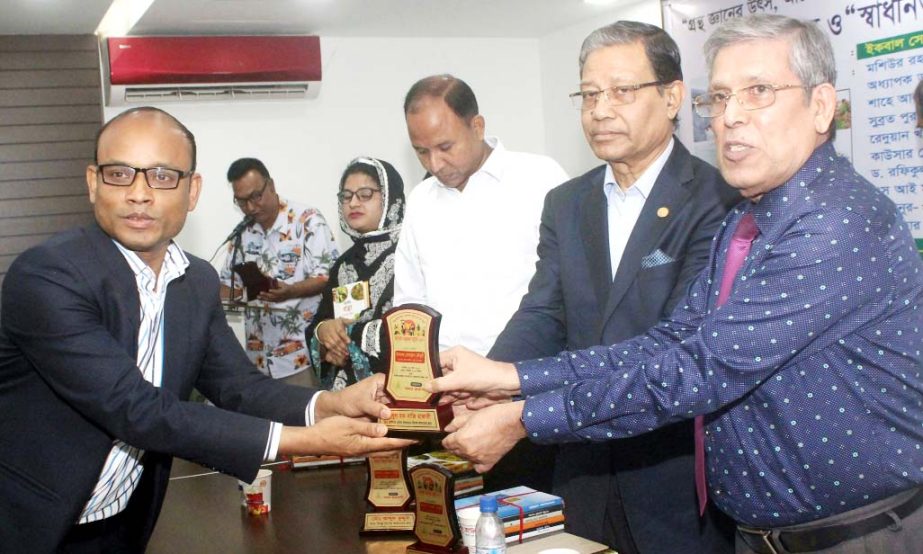 Vice Chancellor of World University Prof Dr Abdul Mannan Chowdhury handing over crest to Shahidul Haque Bappi Hazari for his role in making machine for hatching eggs at a ceremony organised at the Jatiya Press Club on Friday.