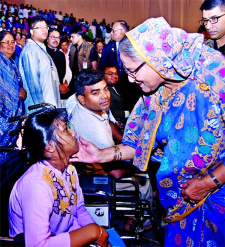 Prime Minister Sheikh Hasina extends her warm affection to girl child victim of autism at the Osmani Auditorium in city marking the 10th World Autism Day on Sunday.