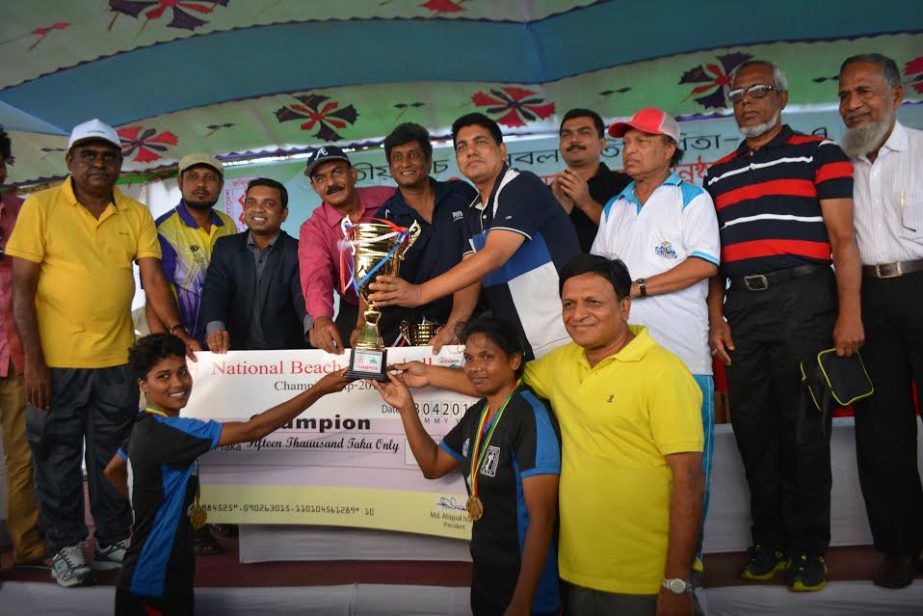 Players of Chittagong District Sports Association receiving Beach Volleyball Championship trophy (Women's Division) at the Sugandha points in Cox's Bazar on Monday.