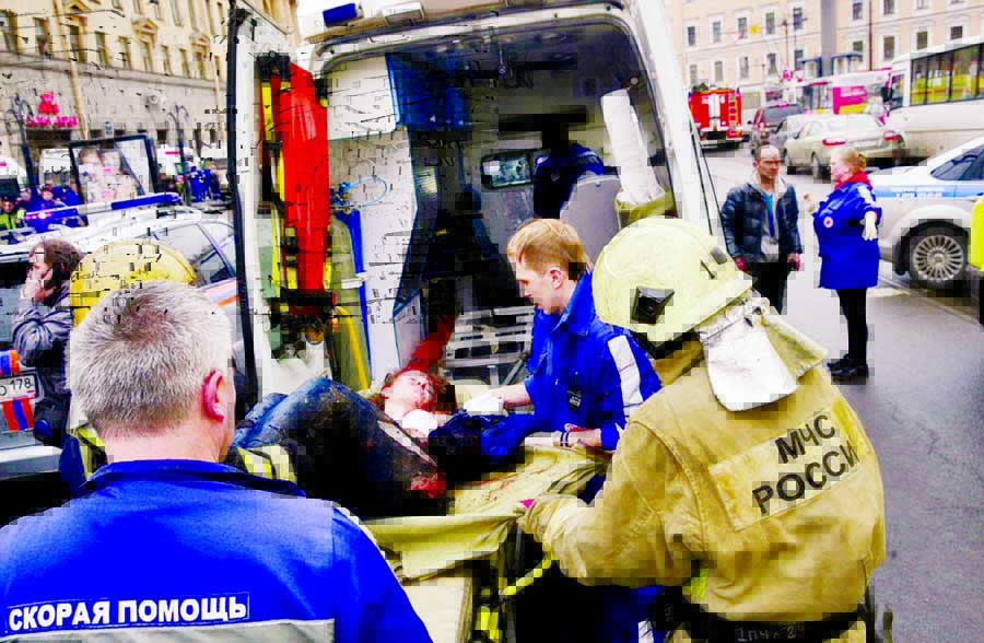 An injured person is helped by emergency services outside Sennaya Ploshchad metro station, following explosions in two train carriages at metro stations.
