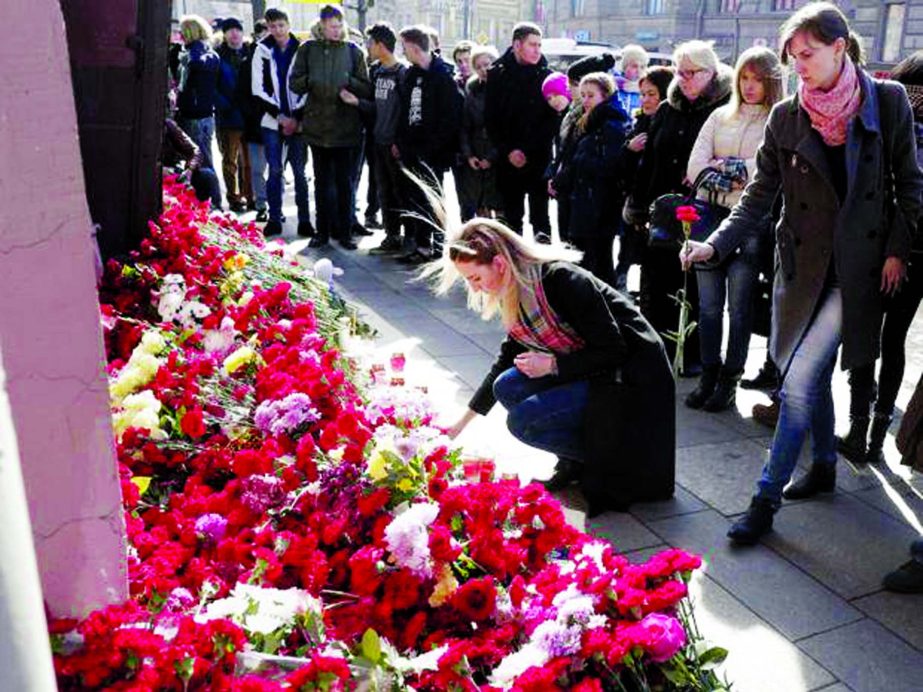 A woman lays flowers at a symbolic memorial outside Tekhnologichesky Institute subway station in St. Petersburg, Russia on Tuesday.