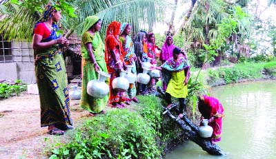 KHULNA: Women are collecting drinking water at Delity Village of Paikgachha Upazila yesterday.