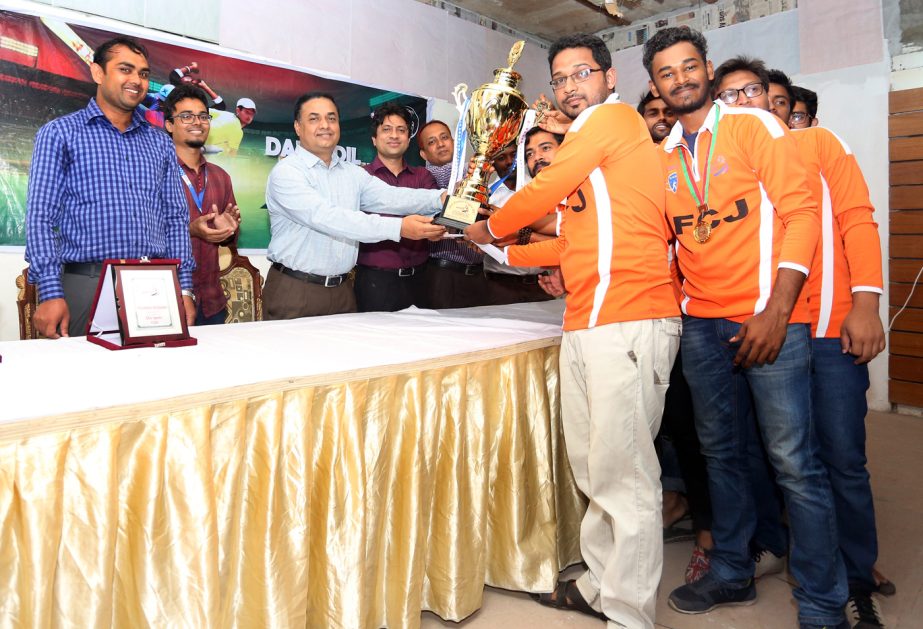 The Executive Director of Daffodil International Academy (DIA) Mohammad Nuruzzaman handing over the trophy to the players of Final Cricket Journey, who became champion of the Daffodil Premier League at the Indira Road TNT field on Wednesday.