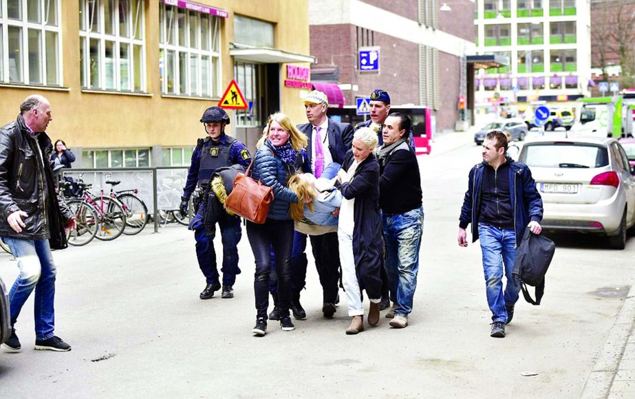 An injured person was seen being carried from the scene by a group of bystanders.