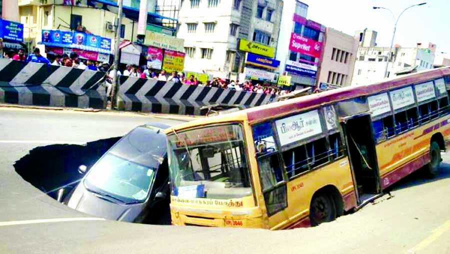 A state bus and a Honda City car trapped in a crater after the Anna Salai road caved in near Church Park street on Sunday afternoon. Internet photo