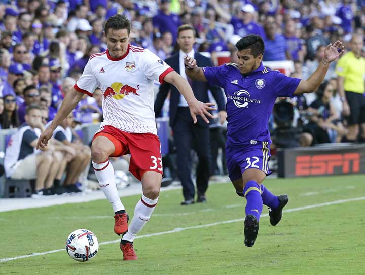 New York Red Bulls's Aaron Long (33) moves the ball past Orlando City's Matias Perez Garcia (32) during the second half of an MLS soccer game on Sunday in Orlando, Fla. Orlando won 1-0.