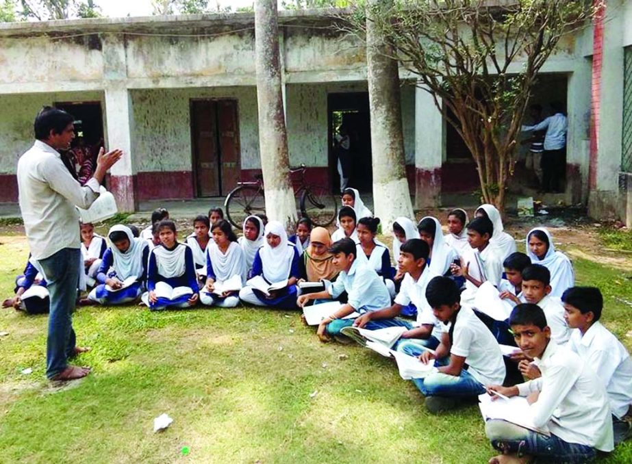 BANARIPARA (Barisal): Students of Gava High School attending classes under open sky due to shortage of class room. This picture was taken yesterday.