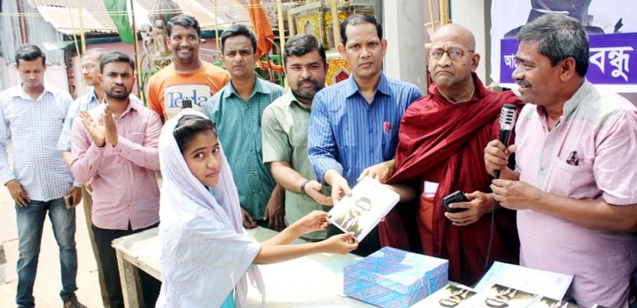 Shuklal Das, General Secretary, Chittagong Press Club distributing the book unfinished biography of Sheikh Mujibur Rahman among the students of Bangabandhu Bangla Bidyapith organised by Bangabandhu and Jatiya Char Neta Smriti Parishad on Wednesday.