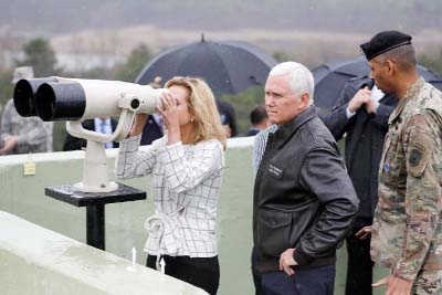 U.S. Vice President Mike Pence stands next to his daughter looking toward the north through a pair of binocular from an observation post inside the demilitarized zone separating the two Koreas, in Paju, South Korea On Monday.