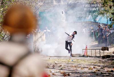 A Kashmiri student throws back a tear-gas canister fired by Indian police during a protest in Srinagar on Monday.