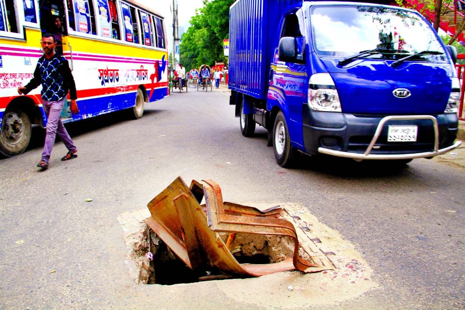 Death trap: Commuters facing a serious obstacle as a big manhole has no cover for long, but the authorities concerned are yet to repair it. This photo was taken from Gulshanâ€™s Notun Bazar area on Wednesday.