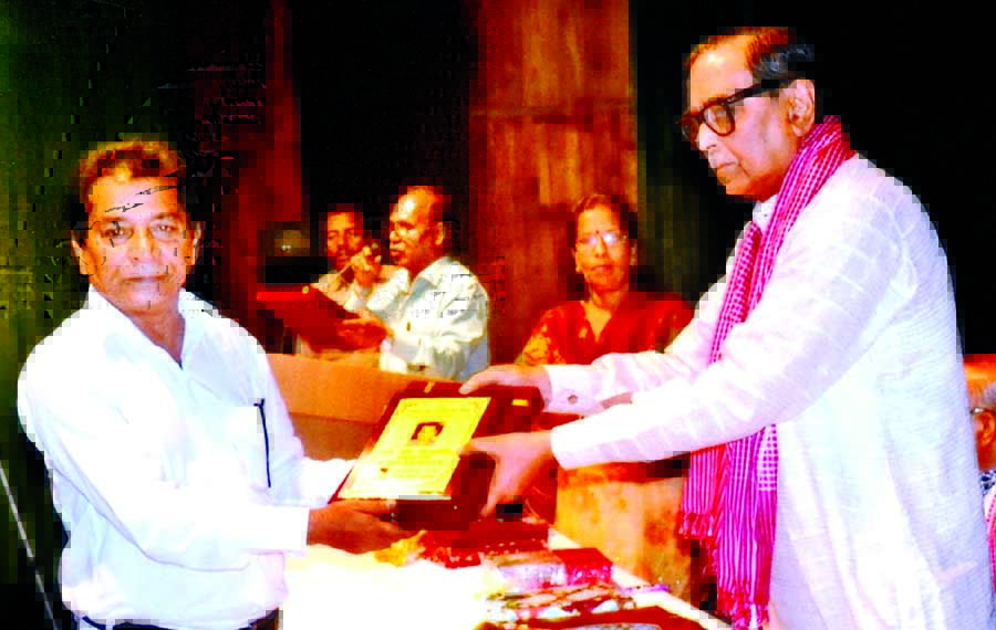 Civil Aviation and Tourism Minister Rashed Khan Menon handing over folk literary citation to Atul Chandra Ojha as the liberation war writer at Shilpakala Academy in the city on Thursday.