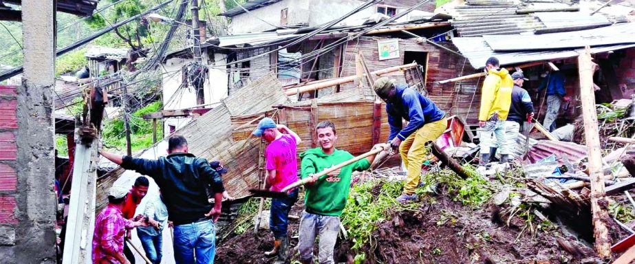 Residents work to unearth a house destroyed during a landslide in Manizales, Colombia.