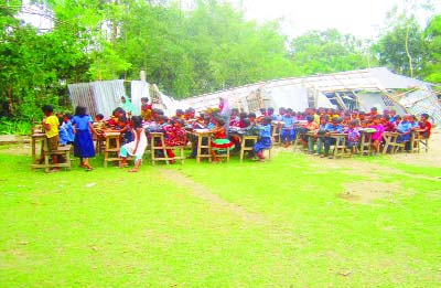 SUNDARGANJ(Gaibandha ): Students of Bekatari Nobo Govt Pry School are attending classes under the open sky as the school was shattered by nor'wester. This snap was taken yesterday.