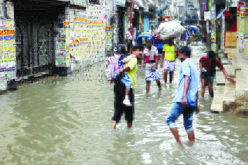 Pedestrians struggling through the ankle-deep water as the road was submerged by the rain water. The snap was taken on Saturday from the city's Aga Sadek Road on Saturday.