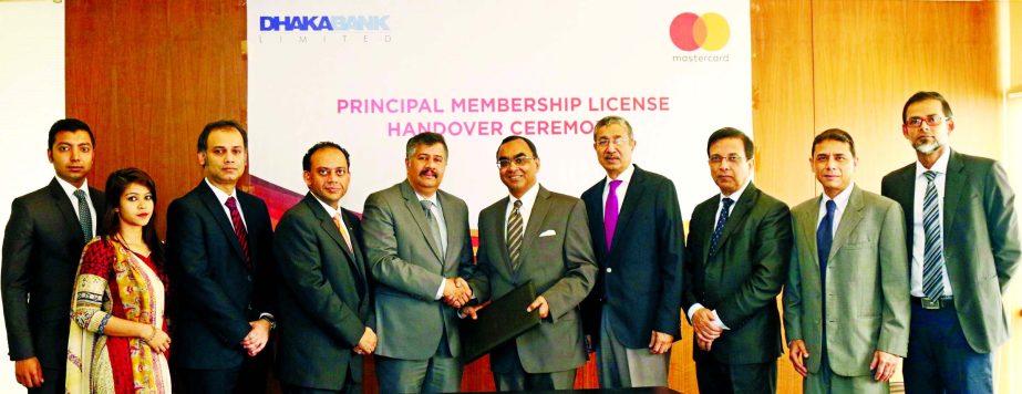Syed Mahbubur Rahman, Managing Director of Dhaka Bank Limited and Syed Mohammad Kamal, Country Manager of Mastercard Bangladesh, exchanging documents after signed a deal at the bank head office in the city recently. Emranul Huq, AMD, Shafquat Hossain, Hea