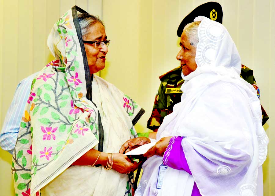 Prime Minister Sheikh Hasina handing over cheques of financial assistance among the heirs of Birshresthas and gallantry award recipient freedom fighters at her office on Sunday. PMO photo