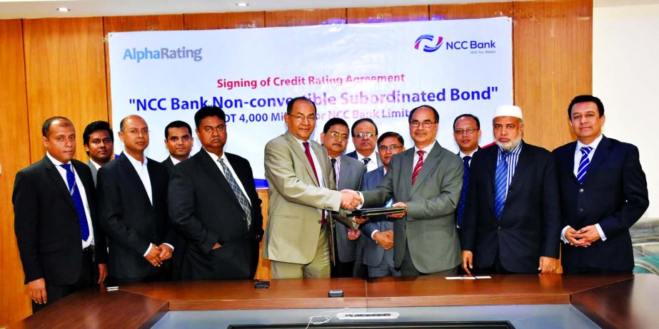 Golam Hafiz Ahmed, Managing Director of NCC Bank Ltd. and Muhammed Asadullah, Managing Director of AlphaRating exchanging signing documents in the city recently. Mosleh Uddin Ahmed, AMD, Md Habibur Rahman, DMD of the bank and Pranabesh Roy, Chief Strategy