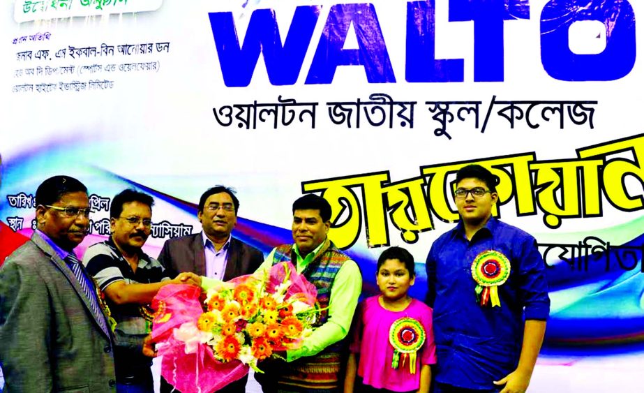 President of Bangladesh Taekwondo Federation Kazi Morshed Hossain Kamal receiving FM Iqbal Bin Anwar Dawn, Operative Director and Head of Sports & Welfare Department of Walton Group with bouquet at the gymnasium of National Sports Council on Tuesday.