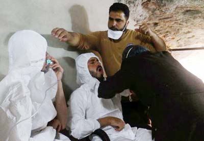 A man breathes through an oxygen mask as another one receives treatments, after what rescue workers described as a suspected gas attack in the town of Khan Sheikhoun in rebel-held Idlib, Syria