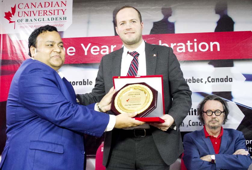 Dennis Dawson, Canadian Senator of Quebec receives crest from Dr Chowdhury Nafeez Sarafat, Chairman of Board of Trustees of Canadian University of Bangladesh at a ceremony to mark the first anniversary of the University recently organized at the Universit