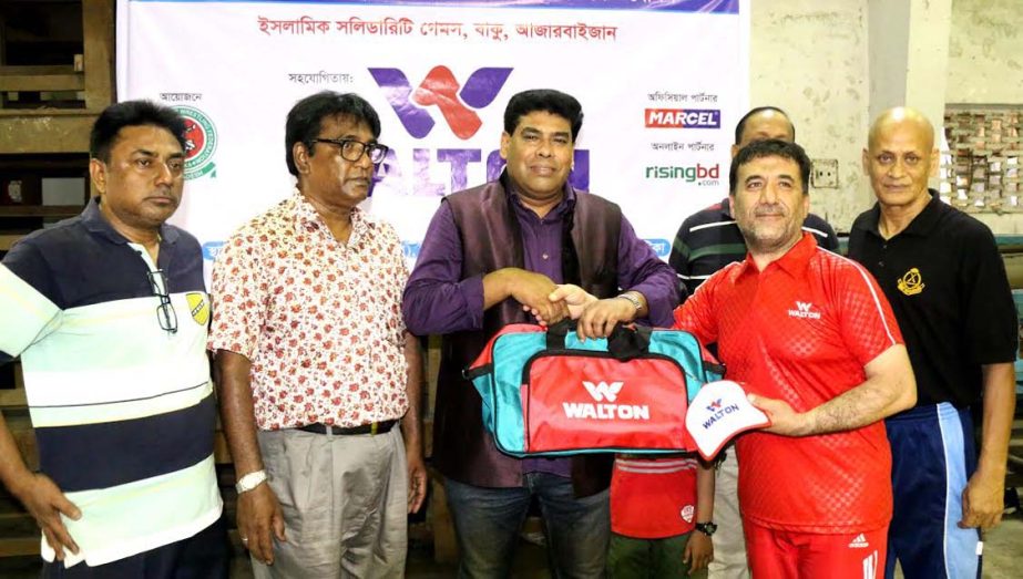 Operative Director and Head of Sports & Welfare Department of Walton Group FM Iqbal Bin Anwar Dawn giving away sports equipment to an Irani Wrestling Coach at the gymnasium of National Sports Council on Saturday. Two Irani Coach arrived in the city to tra