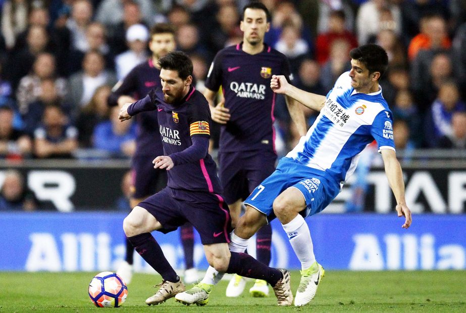 FC Barcelona's Lionel Messi (left) duels for the ball against Espanyol's Gerard Moreno during the Spanish La Liga soccer match between Espanyol and FC Barcelona at RCDE stadium in Cornella Llobregat, Spain on Saturday. Barcelona won the match 3-0.