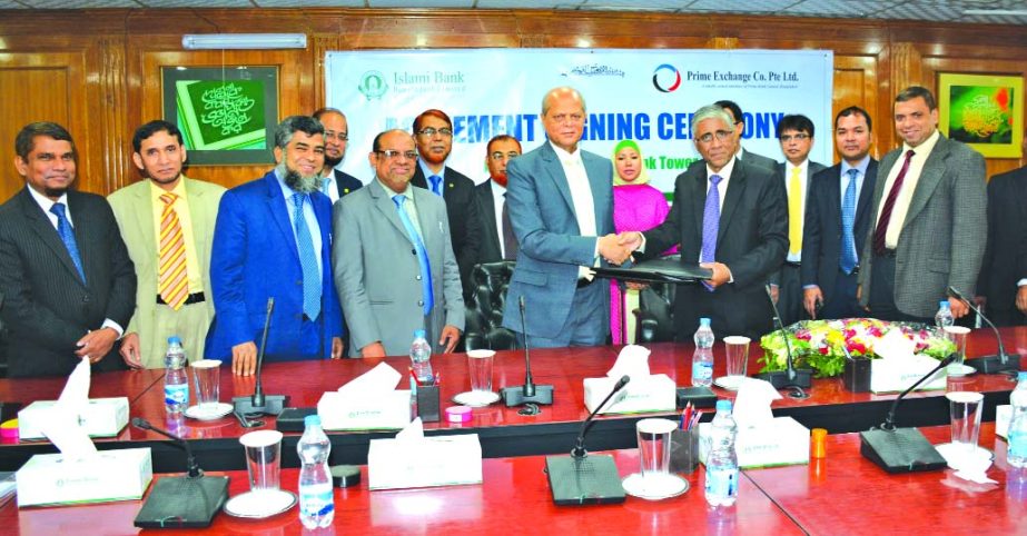 Md Abdul Hamid Miah, Managing Director of Islami Bank and Ahmed Kamal Khan Chowdhury, Managing Director of Prime Exchange Company Ltd, Singapore, exchanging documents after signing a deal at the bank head office on Tuesday in the city. Senior Executives a