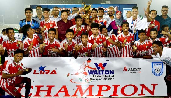 Members of BKSP Under-18 Football team, the champions of the Walton Under-18 Football Championship with the guests and officials of Bangladesh Football Federation pose for a photo session at the Bangabandhu National Stadium on Thursday.