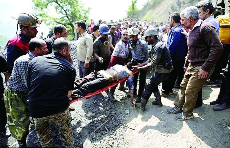 In this picture released by the Tasnim News Agency, miners and rescue personnel carry an injured mine worker after a coal mine explosion, near Azadshahr in northern Iran, where 35 miners were killed on Wednesday.