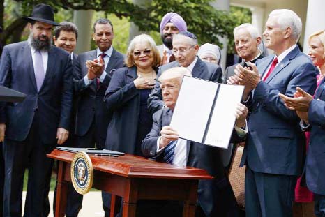 President Trump holds the executive order aimed at easing an IRS rule limiting political activity for churches on Thursday in the White House Rose Garden.