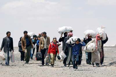 Internally displaced people who fled Raqqa city carry their belongings as they leave a camp in Ain Issa, Raqqa Governorate, Syria.